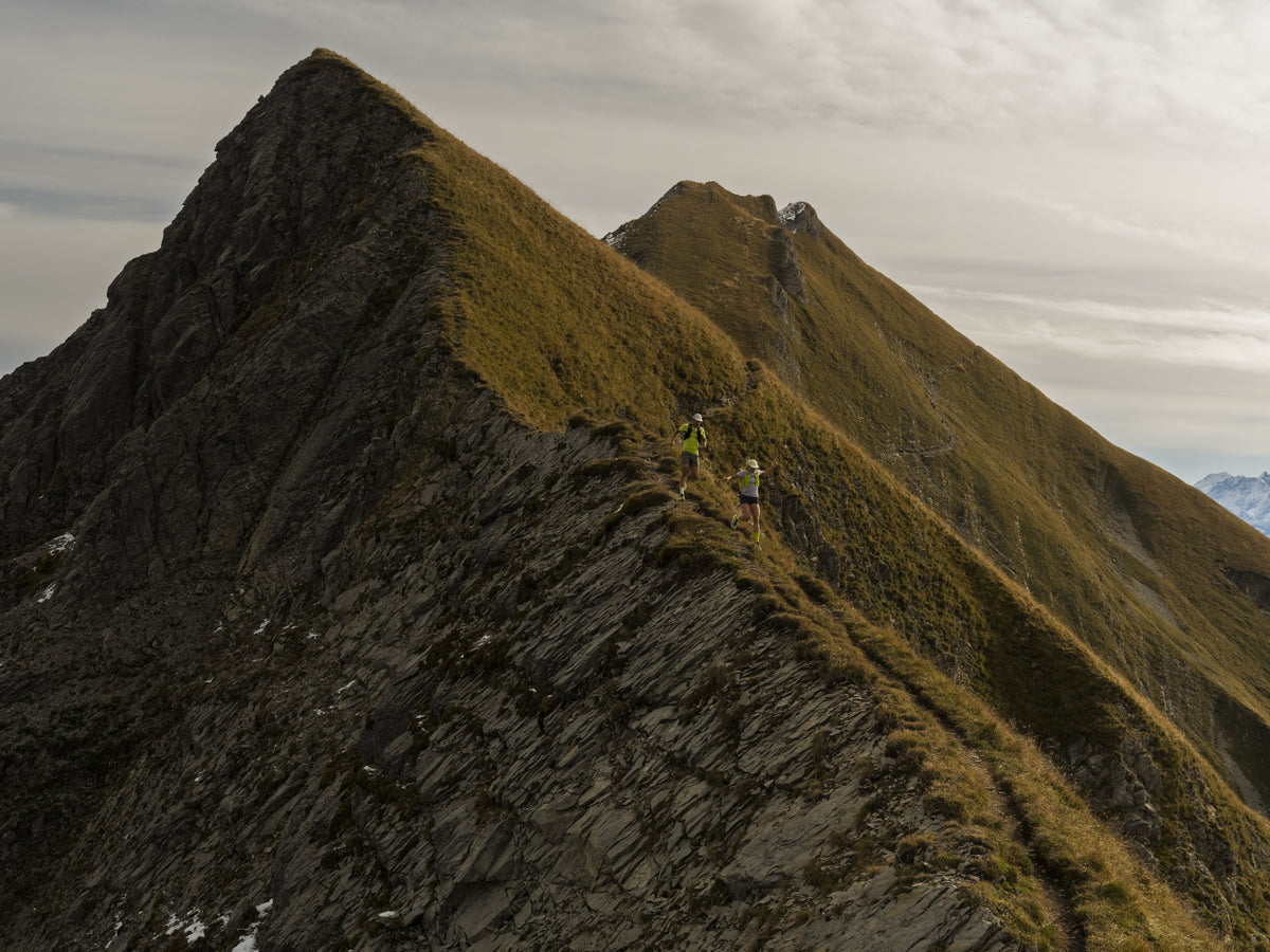 Ridge trail with two distant runners — Arc'teryx Sylan 2 campaign