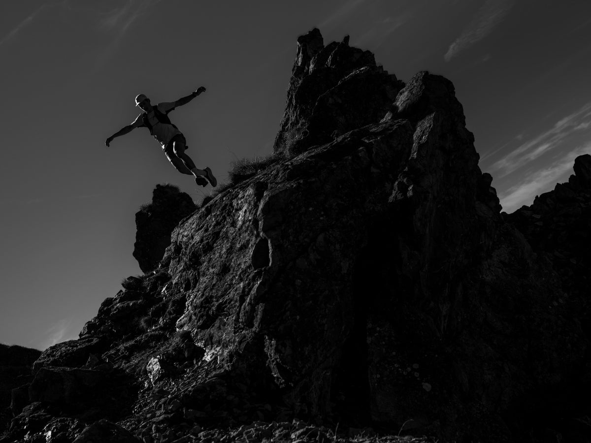 Trail runner jumping between rocks in silhouette — Arc'teryx Sylan 2 campaign